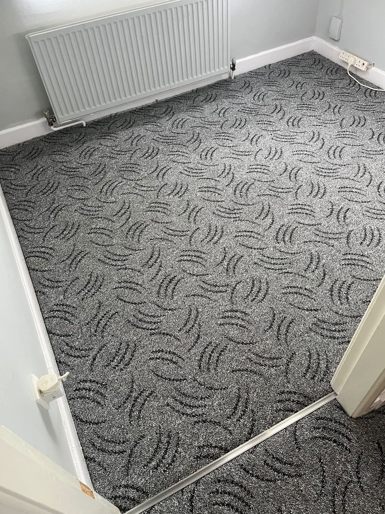 Patterned grey carpet fitted wall to wall in a bedroom